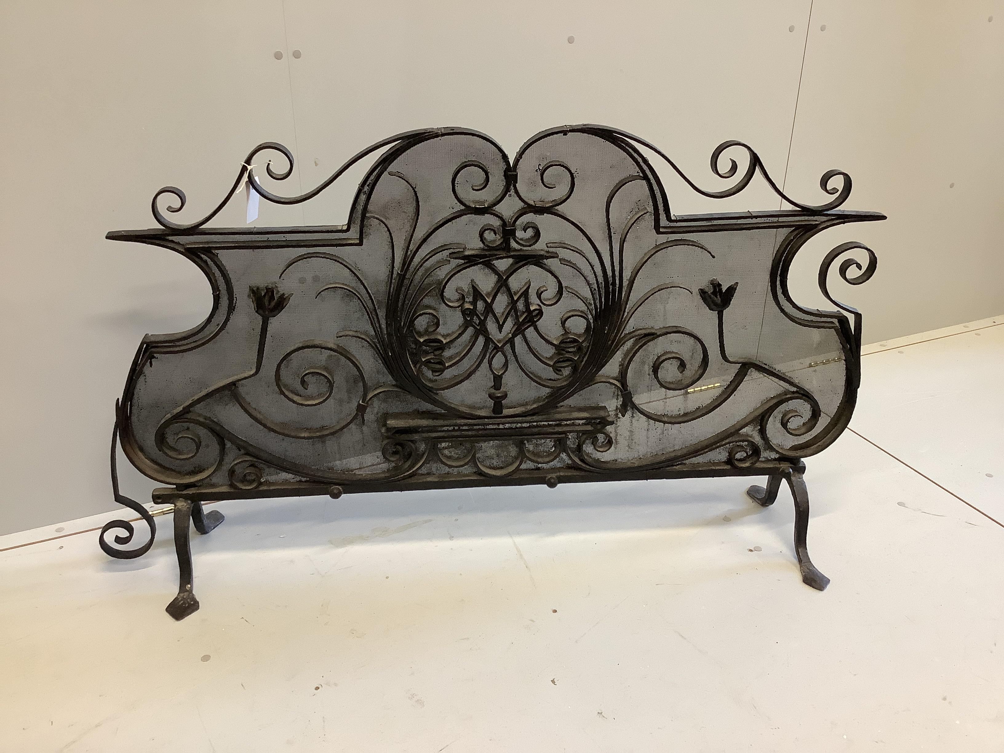A wrought iron and wire mesh fireguard, width 144cm, height 82cm